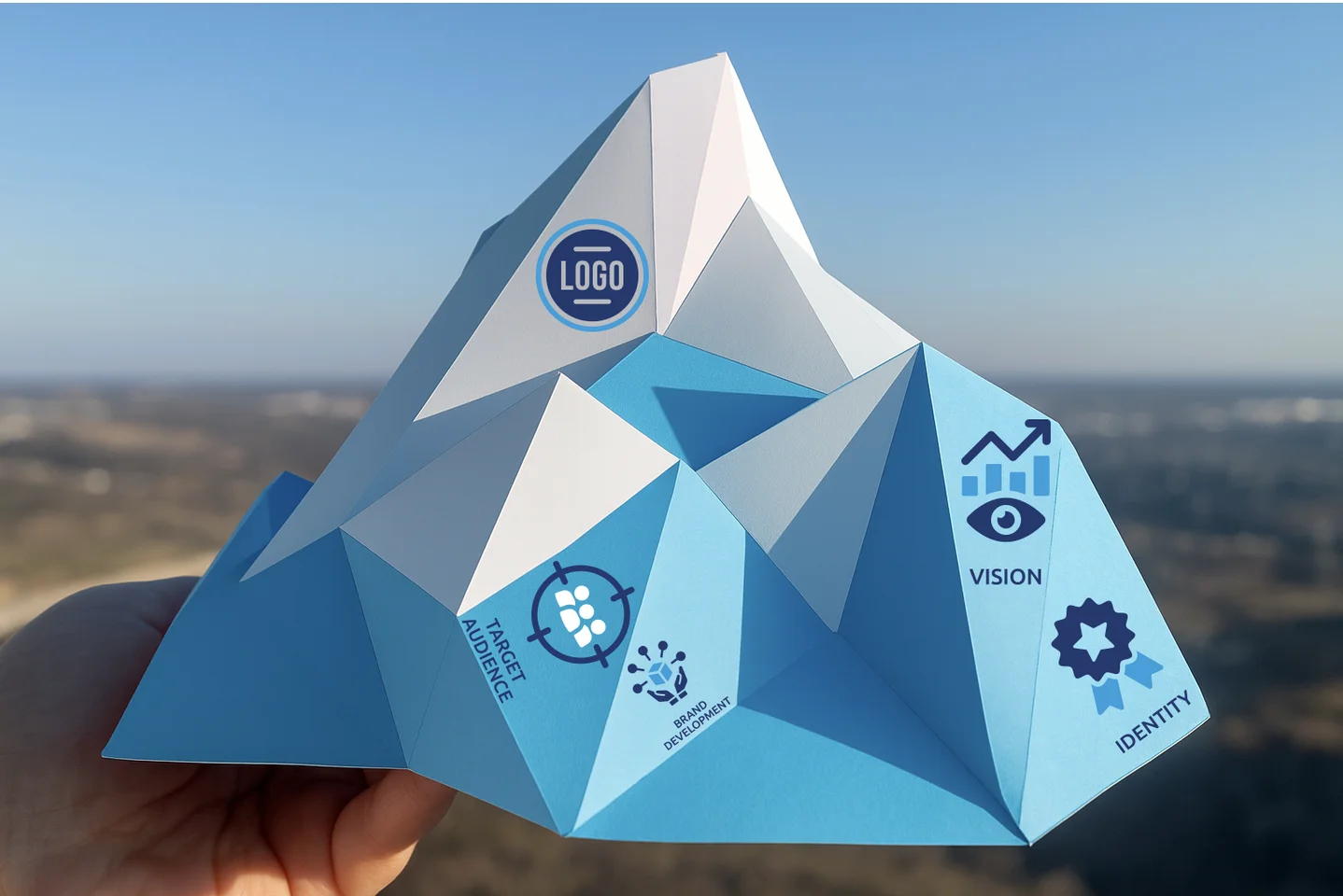 An origami mountain showing icons for brand marketing